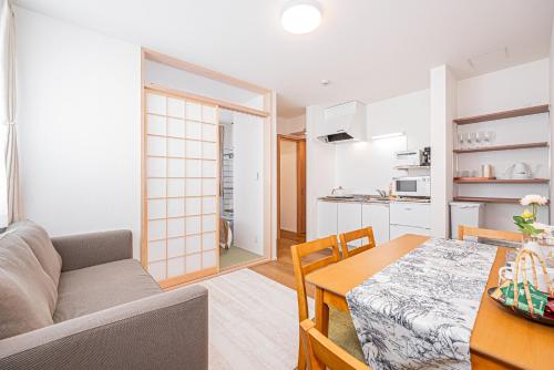 a living room with a table and a kitchen at Kamakura no Nikki in Kamakura