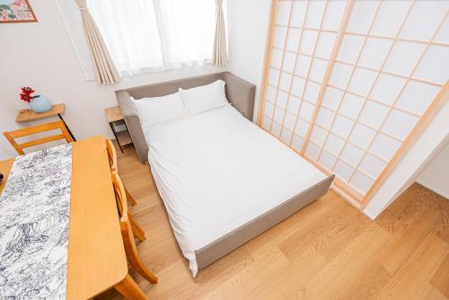 a small bedroom with a bed and a table at Kamakura no Nikki in Kamakura