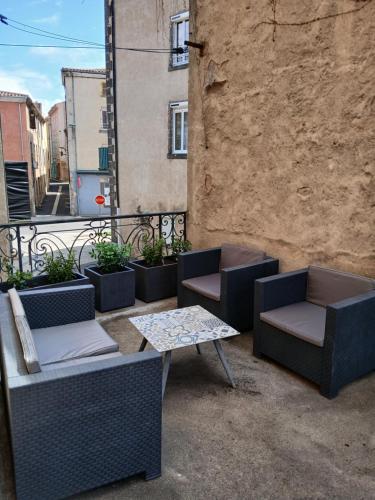 a patio with chairs and a table on a balcony at Villa Toscane in Saint-Germain-Lembron