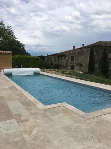 une piscine devant un immeuble dans l'établissement Hibiscus, à Alzonne