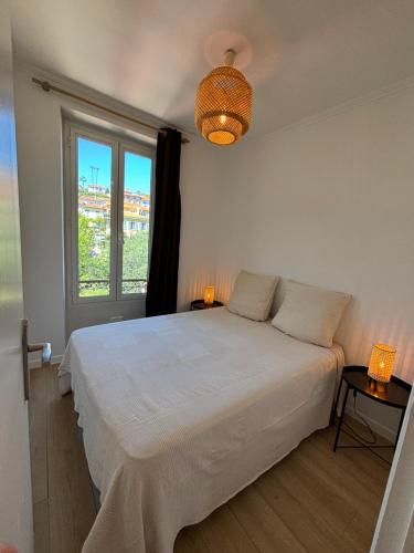 une chambre avec un lit blanc et une fenêtre dans l'établissement 2P Central Nice, à Nice