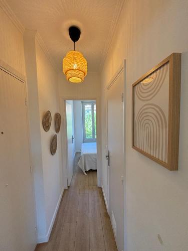 un couloir avec un lustre et une chambre avec un lit dans l'établissement 2P Central Nice, à Nice