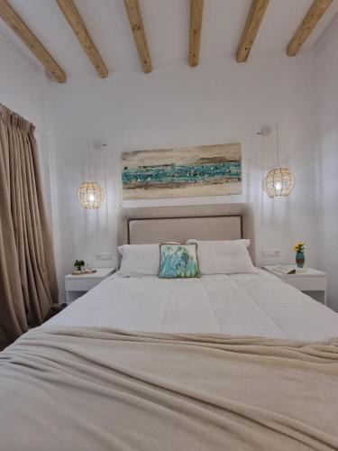 a bedroom with a large white bed with two night stands at Europa Studios in Skala