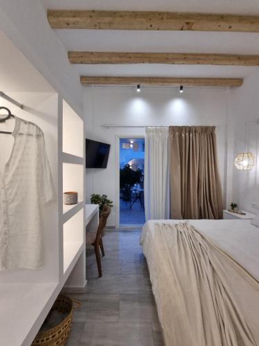 a bedroom with a bed and a desk and a window at Europa Studios in Skala