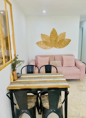 une table dans un salon avec un canapé rose dans l'établissement Appartement 2 chambres 2 salles de bains haute ville, à Porto-Vecchio