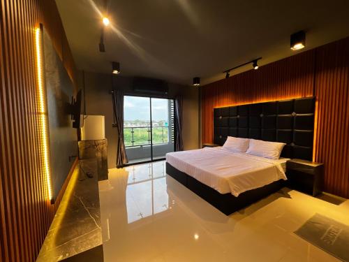 a bedroom with a bed and a large window at Dark Lights Retreat in Na Jomtien