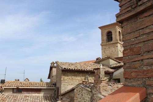a building with a clock tower and a church at La Terrazza sull'Umbria in Collazzone