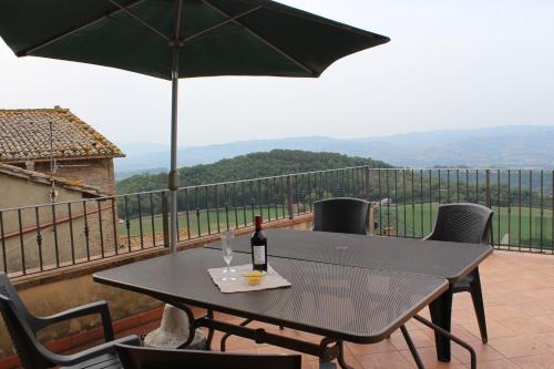 a table with a bottle of wine sitting on a balcony at La Terrazza sull'Umbria in Collazzone