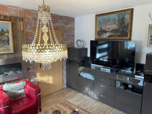 a living room with a chandelier and a tv at Luckylake in Muhr amSee