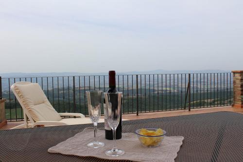 a table with a bottle of wine and two glasses at La Terrazza sull'Umbria in Collazzone