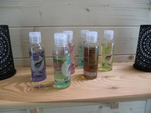 a group of four bottles sitting on a wooden table at B&B Au Coeur de Villers in Villers-Sainte-Gertrude