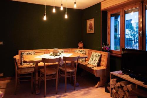 Un comedor con mesa y sillas de madera. en Cà Nòno - Vista Mozzafiato sulle montagne, en Schilpario