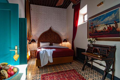 a bedroom with a bed and a table in a room at Riad Callas in Essaouira