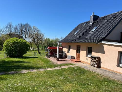 una casa con tetto nero e un cortile di Urlaub Natur Pur OVS 115 a Blowatz