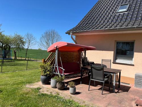 un patio con un tavolo e un ombrellone rosso di Urlaub Natur Pur OVS 115 a Blowatz