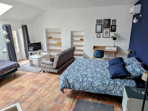a bedroom with a bed and a chair and a desk at Villa de Charme Climatisée - Au coeur des Remparts - Vue panoramique in Montpezat