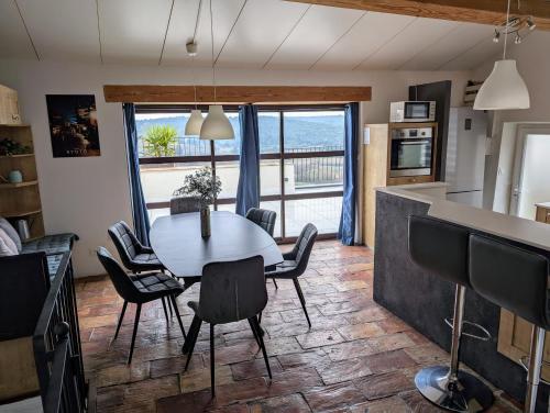 a kitchen and dining room with a table and chairs at Villa de Charme Climatisée - Au coeur des Remparts - Vue panoramique in Montpezat