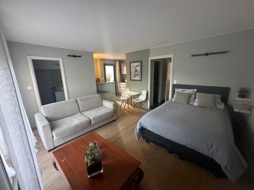 une chambre avec un lit, un canapé et une table dans l'établissement Studio avec jardin Route des sanguinaires Barbicaja, à Ajaccio