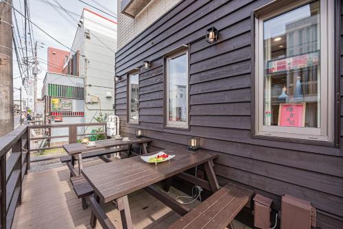 a wooden patio with two benches and a table at Kamakura no Nikki in Kamakura