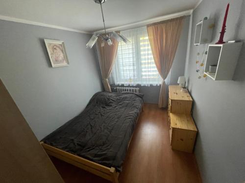 a small bedroom with a bed and a window at Apartament na Szlakowisku in Starachowice
