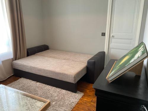 - une petite chambre avec un lit et un bureau avec une fenêtre dans l'établissement Appartement dans maison de ville, proche stade de France et Salon du Bourget, à La Courneuve