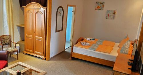 a small bedroom with a bed and a wooden cabinet at Pension Am See in Malchow