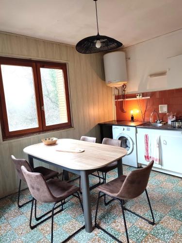 une cuisine avec une table et des chaises dans une pièce dans l'établissement Saint-Michel de Maurienne, appartement de 45 m², à Saint-Michel-de-Maurienne