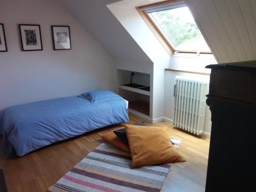 une chambre avec un lit et un tapis au sol dans l'établissement Maison de charme à 300 m de la mer, à Plérin