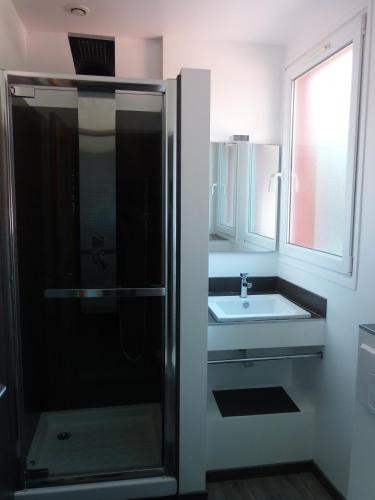 une salle de bain avec douche et lavabo dans l'établissement Maison de charme à 300 m de la mer, à Plérin