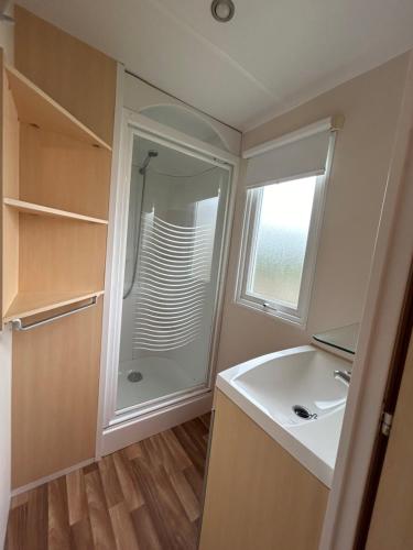 une salle de bain avec un lavabo et une douche dans l'établissement Mobilhome 5 personnes proche Europapark, à Boofzheim