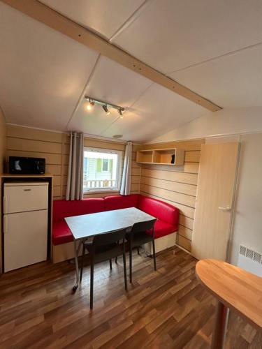 une chambre avec un canapé rouge et une table dans l'établissement Mobilhome 5 personnes proche Europapark, à Boofzheim