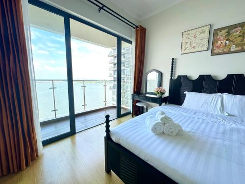 a bedroom with a bed and a large window at Ocean View Family Suite in Johor Bahru