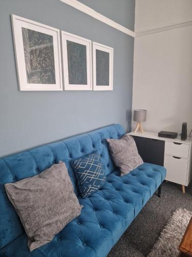 a blue couch in a living room with a desk at Comfortable 3 Double Bed Victorian Terrace from Luxus Stays in Spon End