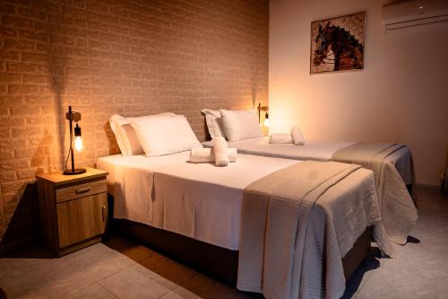 a bedroom with two beds with white sheets and a lamp at Pine View Boutique Hotel Adults Only in Saittas