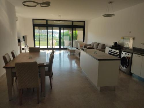 a kitchen and living room with a table and chairs at 3bedroom chalet swan lake North coast- 388B in Zāwiyat al ‘Awwāmah