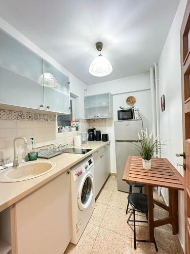 a kitchen with a sink and a washing machine at Sunrise Apartments City Center in Bucharest