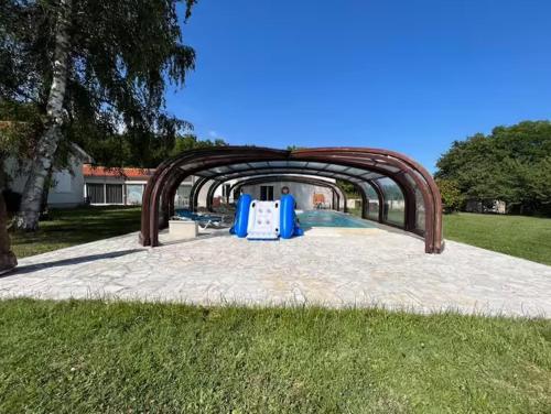 a swimming pool with an archway in a yard at Le Trankiloup in Grézac