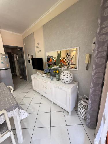 a living room with a white cabinet and a television at Residenza butterfly IUN R6379 in Villasimius