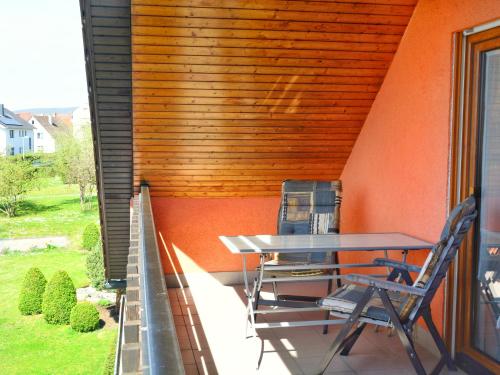 a patio with a table and chairs on a balcony at Ferienwohnung im Mühlengrund in Hofheim in Unterfranken