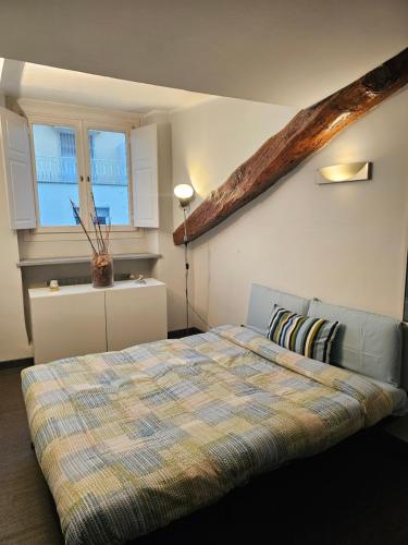 a bedroom with a bed with a plaid bedspread and a window at City Center Heart in Turin