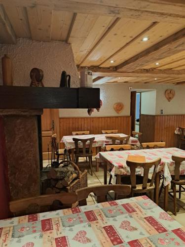 une salle à manger avec des tables et une cheminée dans l'établissement Ferme auberge des Cimes, à Urbeis