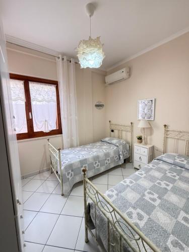 a bedroom with two beds and a chandelier at Residenza butterfly IUN R6379 in Villasimius