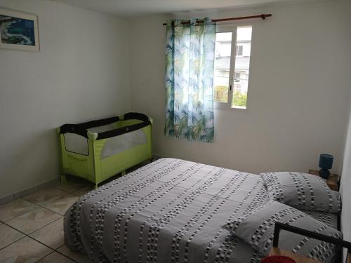 a bedroom with a bed and a window at Maison au Bois-Court in Le Tampon