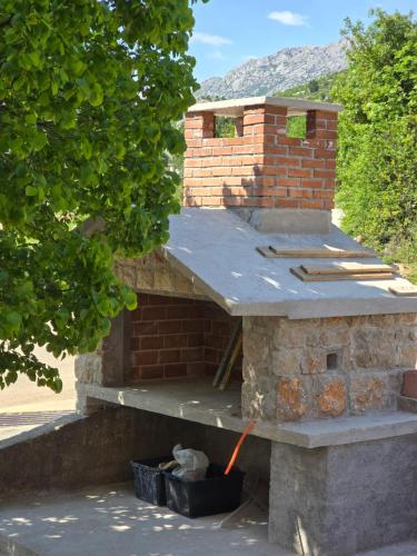 a brick oven with a roof on top of it at Apartment Ante and Dijana in Starigrad-Paklenica
