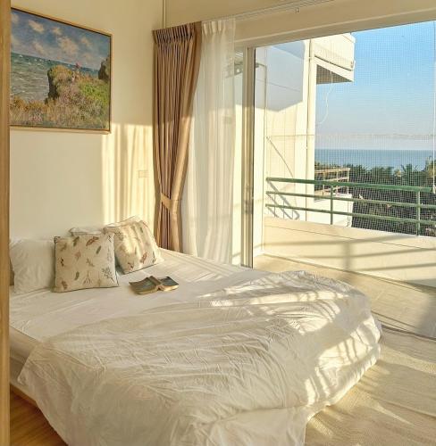 a bedroom with a bed with a view of the ocean at Coastal getaway at Cha-am in Ban Bang Sai Yoi (1)