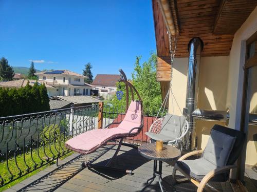 a balcony with two chairs and a table and a swing at Apartmánovy dom Daniela in Prievidza