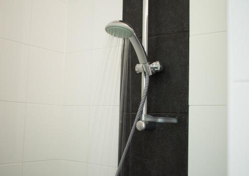 y baño con ducha con cabezal de ducha. en Hotel Hardenberg en Hardenberg
