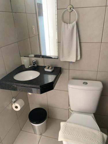 a bathroom with a toilet and a sink and a mirror at Pousada Soleil de Genipabu in Extremóz