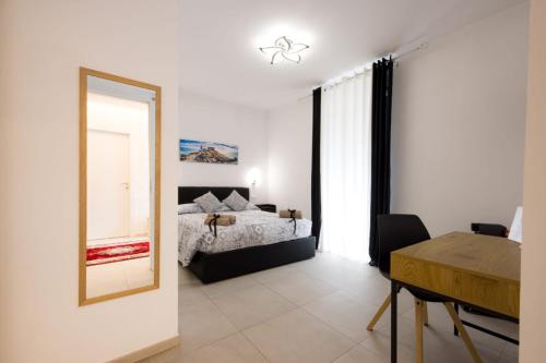 a bedroom with a bed and a mirror and a table at La maison du lion in La Spezia