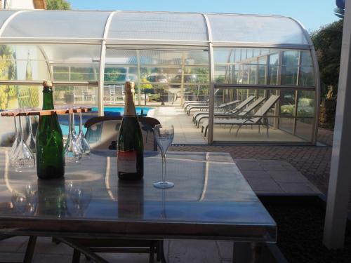 - une table avec 2 bouteilles de vin et un verre dans l'établissement Gîte de l'écurie, à Moussy